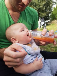 bébé boit à la bouteille du jus orange fraise, pas de problème